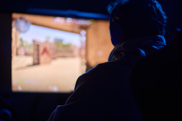 A coder is working late at night on a computer screen, coding and using a smartphone app