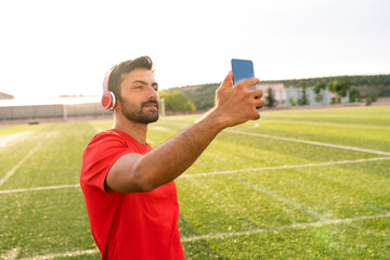 An athlete man takes a selfie with his mobile phone. A man takes a selfie after training in the...