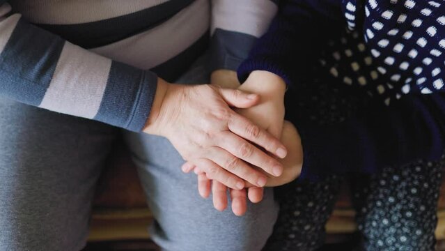 The hands of different generations are united in this close up shot,