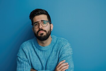 Fototapeta premium Young Hispanic Man with Beard Looking Tired and Bored over Thinking Blue Background