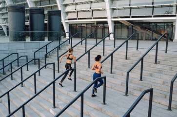 Two attractive female exercising outdoor. Stretching, fitness, sport and healthy lifestyle concept