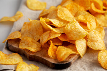 Cheese Potato Chips on a Wooden Board, side view.