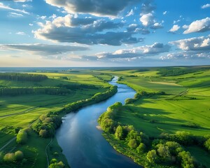 Fototapeta premium Beautiful aerial view of green fields, a river and blue sky with clouds on a sunny day in spring or summer season at sunset time