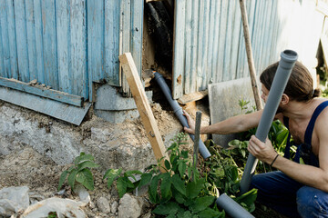 installation of sewer pipes in a rustic wooden house.