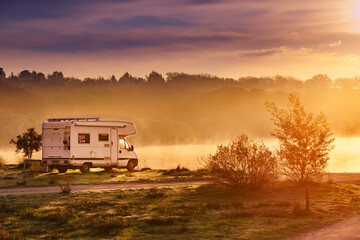 Rv caravan on lake shore. Autumn time, foggy morning