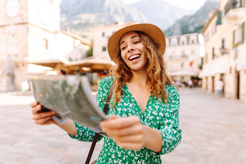 Portrait beautiful woman with paper map on urban street. Vacation concept by exploring interesting places to travel.