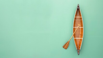 Wooden canoe with paddle on green background displayed vertically