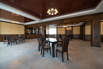 spacious interior of modern empty large restaurant with tables and chairs.