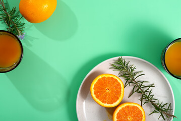 A white plate with Valencia orange, Rangpur fruit, rosemary, served with citrus juice