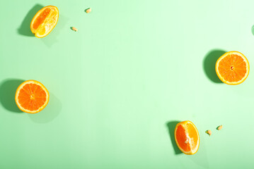 The oranges have been halved and placed on a green surface to emphasize their freshness