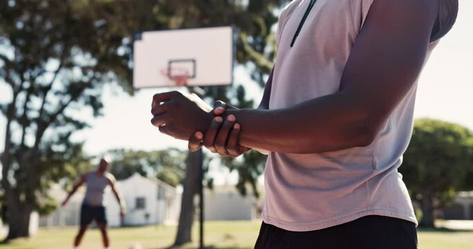 Sports, basketball and man with wrist injury, accident or pain for training or game at outdoor court. Fitness, workout and African male athlete with muscle sprain in hand for match or practice.