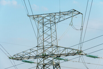 Power lines and high-voltage wires against a background of blue sky and fluffy clouds. Energy infrastructure of Ukraine.