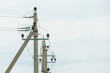 Power lines and high-voltage wires against a background of blue sky and fluffy clouds. Energy infrastructure of Ukraine.