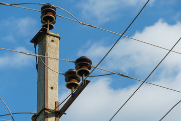 Power lines and high-voltage wires against a background of blue sky and fluffy clouds. Energy...