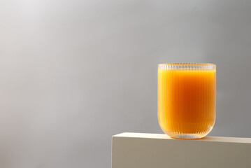 A glass of orange juice on a white ledge with tableware, liquid, and orange drink