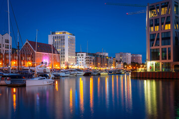 Serene evening at a city marina with glowing reflections on the water