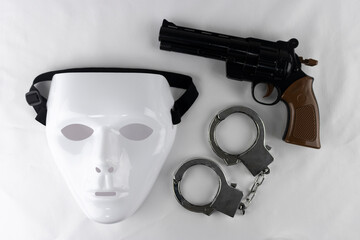 白い仮面とオモチャの拳銃と手錠