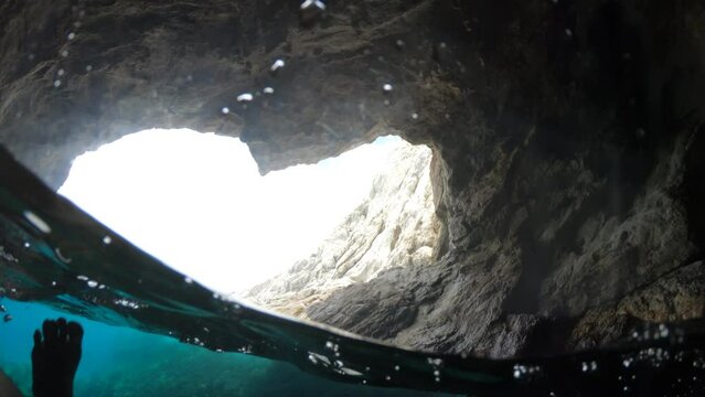 underwater exploration of Blue Cave of Elba Island, with fins in a clear, natural swimming spot, surrounded by the serenity of the underwater world. Tuscan archipelago reserve of Italy in Enfola cape.