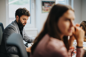 Business professionals in a focused meeting at an office. Colleagues collaborate and brainstorm...