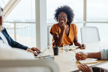 Professional businesswoman engaged in a creative brainstorming session with her team in a modern...