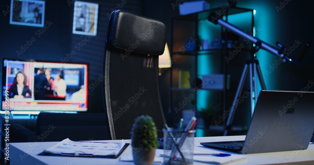 Aufkleber apartment illuminated by rgb lights with office desk in front of smart tv displaying news program br