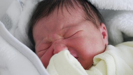 Close-up of newborn baby resting, wrapped in a white blanket. serene expression and delicate features highlight the purity and tranquility of newborn life, capturing a peaceful and tender moment