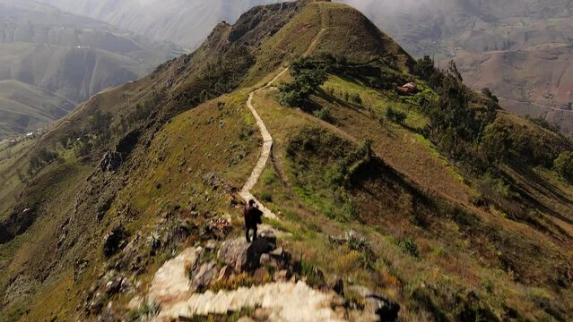Un hombre joven caminando por las monta&ntilde;as.silueta de turista con mochila ,Viaje estilo de vida saludable excursi&oacute;n en solitario vacaciones activas al aire libre, Amplio panorama de monta&ntilde;a,Drone