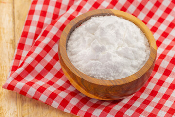 Baking soda in wooden bowl on table