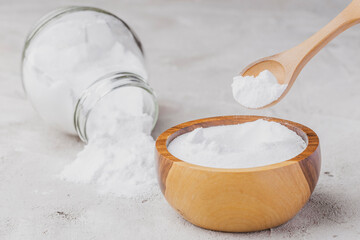 Baking soda in wooden container on rustic surface
