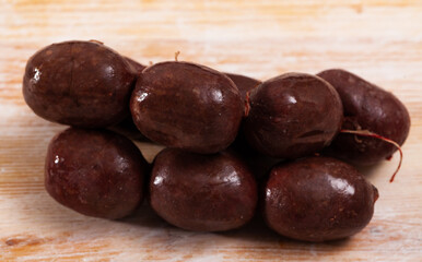 Traditional Spanish gut-shaped blood sausage morcilla on wooden surface..