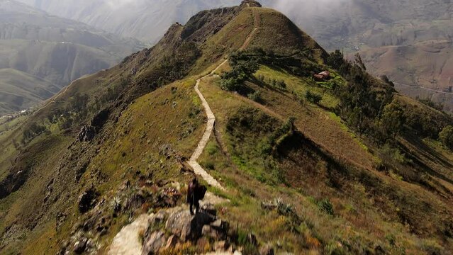 Un hombre joven caminando por las monta&ntilde;as.silueta de turista con mochila ,Viaje estilo de vida saludable excursi&oacute;n en solitario vacaciones activas al aire libre, Amplio panorama de monta&ntilde;a,Drone