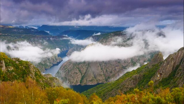 Time lapse of clouds moving over mountain and Douro river with spanish Saucelle Dam. Border between Portugal and Spain. National Parks. View from portuguese Penedo Durao lookout.