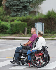 Two friends a woman and a man, wheelchair users spending time outdoors. Life with disability,...