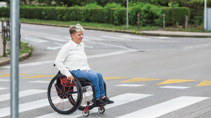 Woman with disability on a wheelchair on the city street.