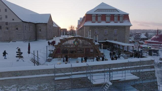 Aerial: Drone Panning Shot Of People At Gotha Christmas Market In City During Winter Season At Sunset - Erfurt, Germany