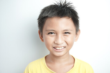 Portrait of a cute little Asian boy smiling against white background