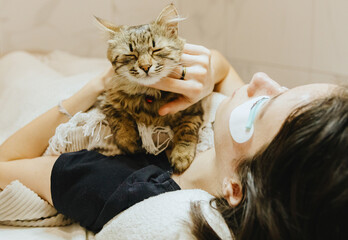 Portrait of a sleeping cat at the feet of a woman.