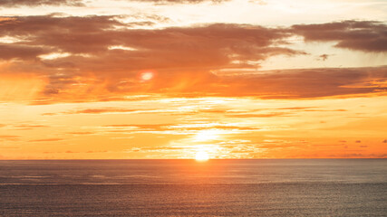 A stunning sunset over the ocean in Bali, with vibrant orange and red hues painting the sky