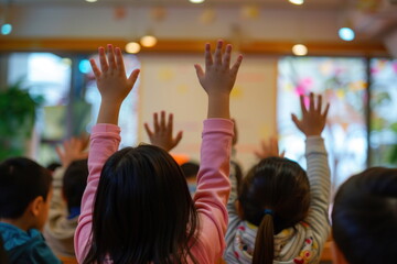 Fototapeta premium Children raise their hands to answer questions in the classroom, Taken from behind