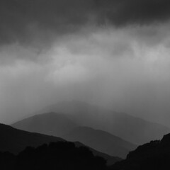 Monochrome shot of storm clouds above mountains.