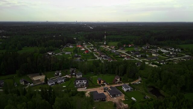 Enjoy breathtaking aerial views of a serene rural settlement nestled in the midst of lush forest greenery