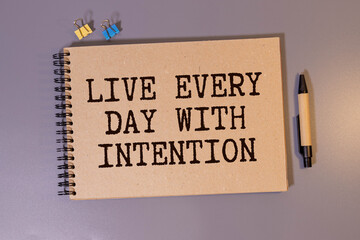 Live every day with intention. Words written under torn paper.