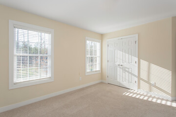 Bright Empty Room with Windows and Beige Walls, Carpet Flooring
