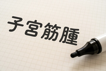 子宮筋腫と書かれたノートとマーカー