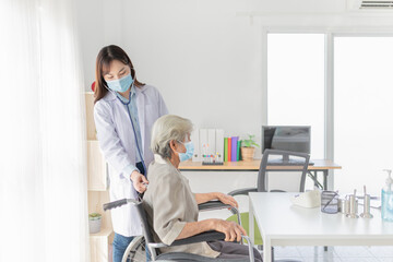 Obraz premium Asian doctor talk with old female patient about disease symptom, doctor use stethoscope listening lung of patient, elderly health check up, they wear surgical mask in hospital, corona virus protection