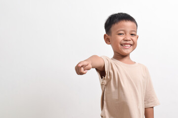 Image of Asian child posing pointing towards the front on a white background. portrait of an Asian...