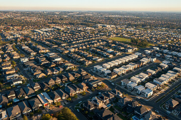 Wide aerial view of streets with similar sized modern Australian homes in Sydney's increasingly sprawling outer suburbs