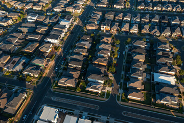 Late afternoon aerial view of streets lined with similar sized modern Australian brick veneer homes in the outer suburbs of Sydney, Australia.