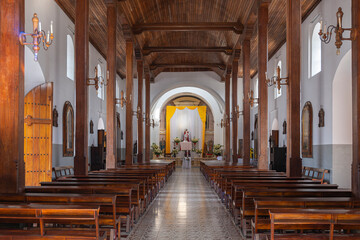 Interior of an empty old catholic church with wooden ceiling and column pillars, Ahuachapan El Salvador.