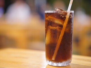 Cola with ice cubes on a dark lights bokeh background